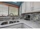 Kitchen sink area featuring tiled backsplash, granite countertops, and stainless steel faucet at 1500 Sunset Rd # G4, Tarpon Springs, FL 34689