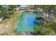 An aerial shot of a fenced tennis court surrounded by trees at 1500 Sunset Rd # G4, Tarpon Springs, FL 34689
