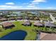 Aerial view of a home surrounded by other homes, lakes, manicured lawns, and mature landscaping at 15635 Sacile Ln, Bradenton, FL 34211
