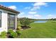 Spacious backyard with lush lawn, mature landscaping, and serene water views at 15635 Sacile Ln, Bradenton, FL 34211