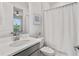 Well-lit bathroom with a shower featuring a white shower curtain and neutral decor at 15635 Sacile Ln, Bradenton, FL 34211