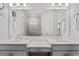 Bright bathroom with double sink vanity, quartz countertop, white walls, mirror and modern lighting at 15635 Sacile Ln, Bradenton, FL 34211