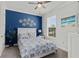 Bright bedroom featuring a blue accent wall, ceiling fan, and a beachy aesthetic at 15635 Sacile Ln, Bradenton, FL 34211