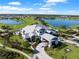 Overhead view of the clubhouse featuring manicured lawns, a golf course, and tranquil lakes at 15635 Sacile Ln, Bradenton, FL 34211