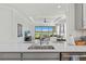 Open concept kitchen with bar seating overlooking the living room and scenic lake view at 15635 Sacile Ln, Bradenton, FL 34211