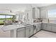 Bright kitchen with white cabinets and countertops with a view of the living room and lake at 15635 Sacile Ln, Bradenton, FL 34211