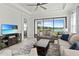 Comfortable living room with large windows and picturesque lake views beyond the sliding glass door at 15635 Sacile Ln, Bradenton, FL 34211