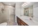 Beautiful bathroom featuring a double sink vanity, tile shower, and large mirror at 18184 Turning Leaf Cir, Land O Lakes, FL 34638