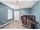 Office/bedroom with a wooden ceiling fan, plank flooring, and large window letting in natural light at 18184 Turning Leaf Cir, Land O Lakes, FL 34638