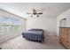 Bright bedroom with a ceiling fan and a window offering outside views, next to a dresser at 18184 Turning Leaf Cir, Land O Lakes, FL 34638