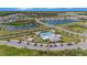 Aerial view showcasing a community pool, playground, lakes, and well-maintained homes at 18184 Turning Leaf Cir, Land O Lakes, FL 34638