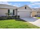 Charming single-story home with a well-manicured lawn and attached two-car garage at 18184 Turning Leaf Cir, Land O Lakes, FL 34638