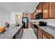 Modern kitchen featuring granite countertops, stainless steel appliances, tile flooring, and wooden cabinetry at 18184 Turning Leaf Cir, Land O Lakes, FL 34638