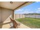 Relaxing covered patio with seating, overlooking a fenced backyard and lake at 18184 Turning Leaf Cir, Land O Lakes, FL 34638
