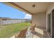 Covered patio with two chairs overlooking a lawn and serene water view at 18184 Turning Leaf Cir, Land O Lakes, FL 34638