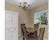 Cozy dining area with a classic chandelier, storage cabinet, and a window letting in natural light at 1830 Bough Ave # 2, Clearwater, FL 33760