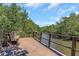 Scenic wooden dock with bench overlooking tranquil canal surrounded by lush green trees under a blue sky at 1830 Bough Ave # 2, Clearwater, FL 33760