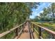 Scenic wooden walkway amidst lush greenery, providing a tranquil outdoor experience near tennis courts at 1830 Bough Ave # 2, Clearwater, FL 33760
