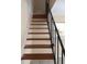 Staircase with wood treads and black metal railing leading to the second floor, showcasing modern design at 1830 Bough Ave # 2, Clearwater, FL 33760