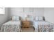 Charming bedroom featuring two twin beds with colorful coral patterned bedding at 19823 Gulf Blvd # 33, Indian Shores, FL 33785