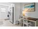 Bright dining area features a wooden table, seating for two, and stainless steel appliances in the kitchen at 19823 Gulf Blvd # 33, Indian Shores, FL 33785