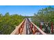 Wooden dock with scenic water view and 'No Swimming' sign, surrounded by lush greenery at 19823 Gulf Blvd # 33, Indian Shores, FL 33785