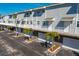 Townhome featuring private garages, white railings, and manicured palm trees at 19823 Gulf Blvd # 33, Indian Shores, FL 33785