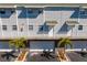 Townhome featuring white railings, individual entrances, and landscaped palm trees at 19823 Gulf Blvd # 33, Indian Shores, FL 33785