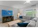 Relaxing living area featuring a gray sectional sofa and a flat screen television with a balcony view at 19823 Gulf Blvd # 33, Indian Shores, FL 33785