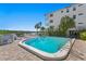 Community pool with lounge chairs and views of the water, surrounded by landscaping and condos at 19823 Gulf Blvd # 33, Indian Shores, FL 33785