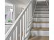 Bright staircase featuring wood treads and white risers, paired with a view of a light and airy bathroom at 19823 Gulf Blvd # 33, Indian Shores, FL 33785