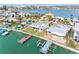 Aerial view of home with dock, palm trees, and canal at 203 Bath Club N Blvd, North Redington Beach, FL 33708