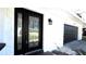 Close up of the home's beautiful front door and dark painted garage at 210 Lake Hobbs Rd, Lutz, FL 33548