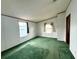 Bright bedroom featuring green carpet, with two windows letting in natural light at 215 S Port Royal Ln, Apollo Beach, FL 33572