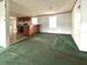 Open-concept living space with kitchen views, green carpet, and ample natural light at 215 S Port Royal Ln, Apollo Beach, FL 33572