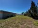 View of the backyard with grass and a partial view of the side of the house at 21838 Edgewater Dr, Port Charlotte, FL 33952
