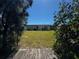 View of backyard with large sliding doors and green grass taken from a wooden deck at 21838 Edgewater Dr, Port Charlotte, FL 33952