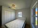 This bedroom features a closet, a large window, and a modern light fixture over a bed with a white platform at 21838 Edgewater Dr, Port Charlotte, FL 33952