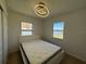 This bedroom features a large window and a modern light fixture over a bed with a white platform at 21838 Edgewater Dr, Port Charlotte, FL 33952