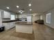 Well-lit kitchen with granite countertops, an island, white cabinets, and views into the living room at 21838 Edgewater Dr, Port Charlotte, FL 33952