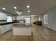 Well-lit kitchen with granite countertops, an island, white cabinets, and views into the living room at 21838 Edgewater Dr, Port Charlotte, FL 33952