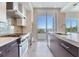 Bright kitchen with island, stainless gas range and cooktop, tiled floors, and a scenic view at 2910 W Barcelona St # 403, Tampa, FL 33629