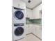 Modern laundry room with stacked washer/dryer, sleek cabinetry, and tiled backsplash at 2910 W Barcelona St # 403, Tampa, FL 33629
