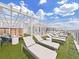 Modern rooftop featuring multiple sun loungers, seating, and a white pergola overlooking the beautiful sky at 2910 W Barcelona St # 403, Tampa, FL 33629
