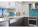 Modern kitchen with stainless appliances, granite countertops, grey cabinets, and blue tile backsplash at 3301 Bayshore Blvd # 2108B, Tampa, FL 33629