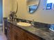 Traditional bathroom featuring double mirrors, dark countertops and custom wood cabinetry at 3316 S Shamrock Rd, Tampa, FL 33629