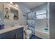 Bathroom with blue vanity, chevron shower curtain and window to the bath and shower combo at 3504 N 12Th St, Tampa, FL 33605