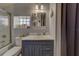 The updated bathroom offers a furniture-style vanity, tiled shower and storage shelving at 3504 N 12Th St, Tampa, FL 33605