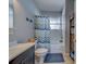 Bathroom features a vanity with a grey cabinet, a toilet, and a shower with blue chevron curtain at 3504 N 12Th St, Tampa, FL 33605