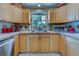 Kitchen with light wood cabinets, tile backsplash, and a stainless steel sink under a window at 3504 N 12Th St, Tampa, FL 33605